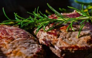 Steaks und anderes Fleisch in einer Gusseisernen Pfanne anbraten